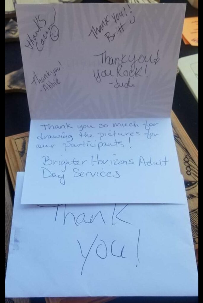 Thank you note on a table folded open with 'thank yous' and signatures. Reads: "Thank you so much for drawing the pictures for our participants! - Brighter Horizons Adult Day Services"